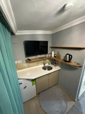 a small kitchen with a sink and a tv at Nelly Guesthouse in Istanbul