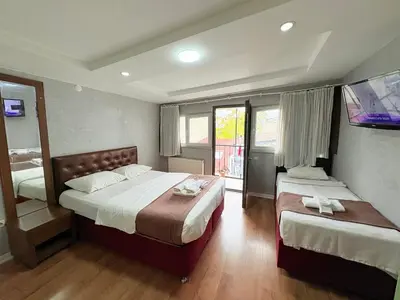 a bedroom with two beds and a flat screen tv at Taksim Otto suite in Istanbul