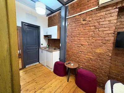 a room with a brick wall and a table and purple stools at Taksim Otto suite in Istanbul