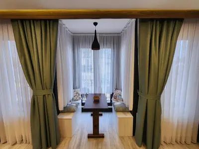 a room with curtains and a table in front of a window at Taksim Landhouse Hotel in Istanbul