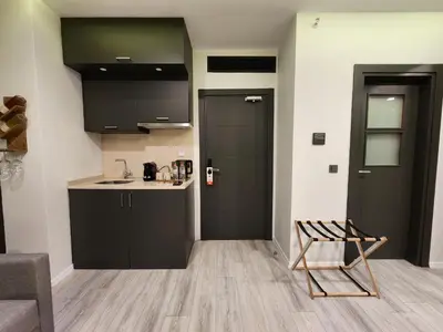 a kitchen with black cabinets and a chair in a room at Taksim Landhouse Hotel in Istanbul