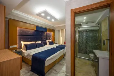 a bedroom with a large bed and a bathroom at Tamara Residence Hotel İstanbul in Istanbul