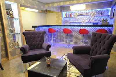 a waiting room with chairs and a bar with red stools at Tamara Residence Hotel İstanbul in Istanbul