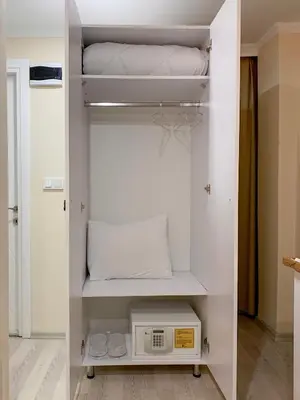a white closet with a microwave on a shelf at Vander Valk İstanbul Hotel in Istanbul
