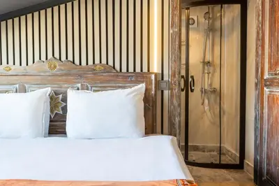a bed with white pillows next to a shower at Wonder Wood Hotel in Istanbul