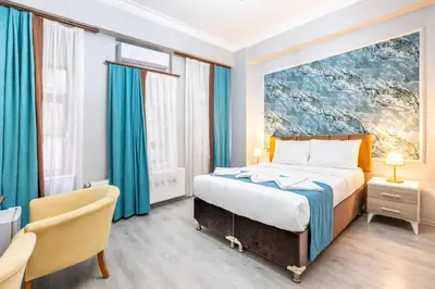 a bedroom with a large bed with blue curtains at Taksim Dora Hotel in Istanbul