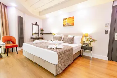 a bedroom with a large bed and a orange chair at Antusa Design Hotel & Spa in Istanbul