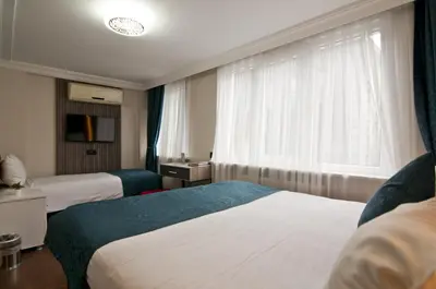 a hotel room with two beds and a window at Genius Hotel Istanbul in Istanbul