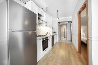 a kitchen with a stainless steel refrigerator and white cabinets at Beddington Residence Sisli in Istanbul