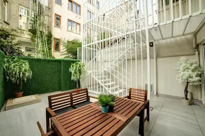 a patio with a wooden table and two benches at Beddington Residence Sisli in Istanbul