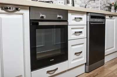 a black oven in a kitchen with white cabinets at Beddington Residence Sisli in Istanbul