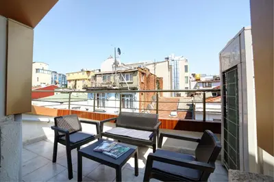 a balcony with chairs and a table and a view of a city at Beddington Residence Sisli in Istanbul