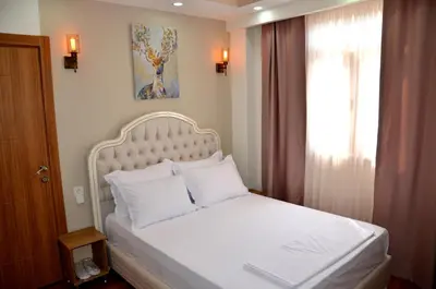 a bedroom with a white bed with a window at PALMERA OLD CITY in Istanbul