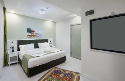 a bedroom with a large bed and a flat screen tv at OBAHAN HOTEL-Special Class in Istanbul