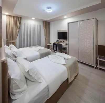 a hotel room with two beds and a television at OBAHAN HOTEL-Special Class in Istanbul