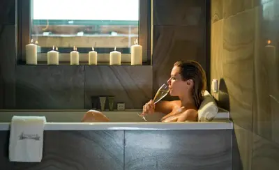 a woman sitting in a bathtub brushing her teeth at Lasagrada Hotel Istanbul in Istanbul