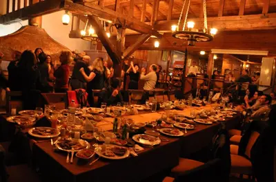 a long table with plates of food and people in a room at Heybeli Garden in Bursa
