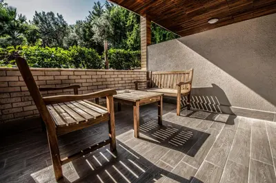 two wooden benches and a table on a patio at Heybeli Garden in Bursa