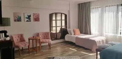 a bedroom with a bed and two chairs and a window at Fuego Design Suites in Istanbul
