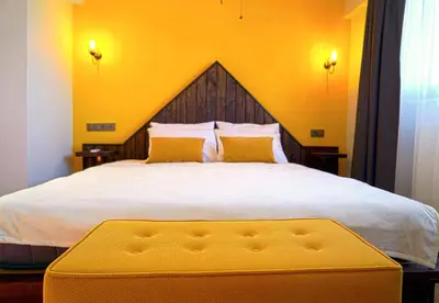a bedroom with a large bed with a yellow wall at Fuego Design Suites in Istanbul