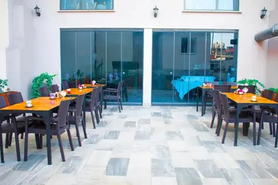 a restaurant with wooden tables and chairs on a patio at Mayer Hotel Istanbul in Istanbul