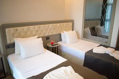 a hotel room with two beds and a mirror at Mayer Hotel Istanbul in Istanbul