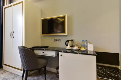 a room with a desk with a chair and a tv at Kare Hotel Sultanahmet in Istanbul