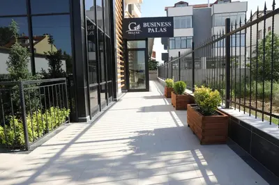 a sidewalk in front of a building with potted plants at BUSINESSPALAS DELUXE in Izmit