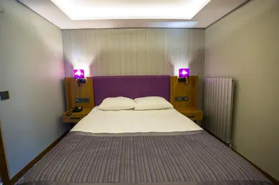 a bedroom with a large bed with two lights on it at BUSINESSPALAS DELUXE in Izmit