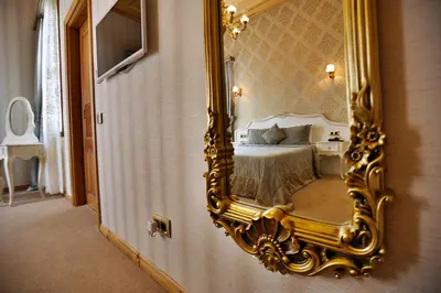 a bedroom with a bed and a gold mirror at Ada Palas Buyukada in Buyukada