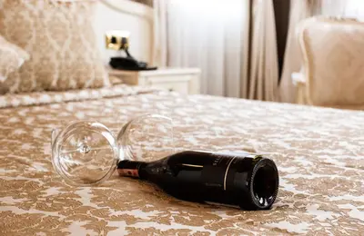 a bottle of wine laying on a bed at Ada Palas Buyukada in Buyukada