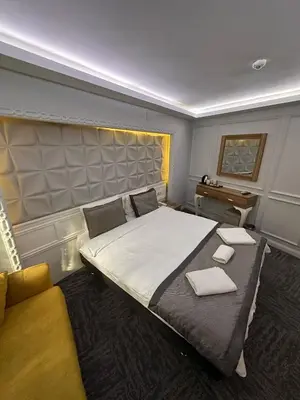 a bedroom with a large bed and a couch at Grand Heykel Hotel in Bursa