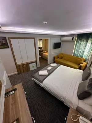 a large bedroom with a large bed and a couch at Grand Heykel Hotel in Bursa