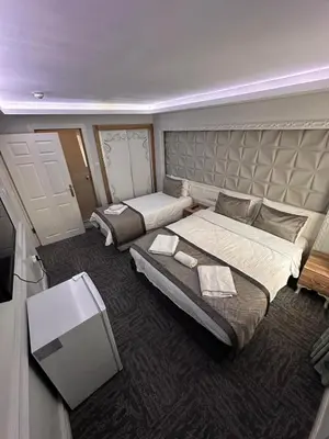a large bedroom with two beds and a television at Grand Heykel Hotel in Bursa