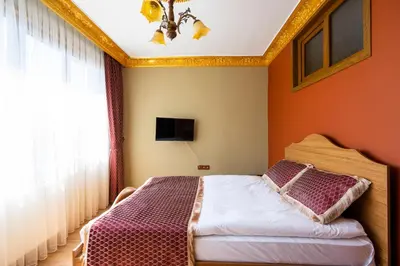 a bedroom with a bed with orange walls and a window at The Ottoman Desing Suit in Istanbul