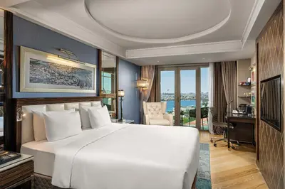 a bedroom with a large white bed and a desk at Radisson Blu Hotel Istanbul Pera in Istanbul