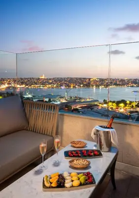 a table with food and wine glasses on a balcony at Radisson Blu Hotel Istanbul Pera in Istanbul