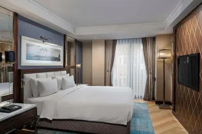 a bedroom with a large white bed and a tv at Radisson Blu Hotel Istanbul Pera in Istanbul