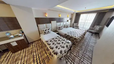 a hotel room with two beds and a table at Green Prusa Hotel in Bursa