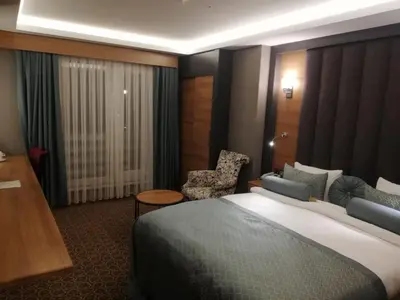 a hotel room with a bed and a chair at Green Prusa Hotel in Bursa