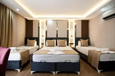 a hotel room with three beds and a couch at Grand Bagoz Hotel in Istanbul