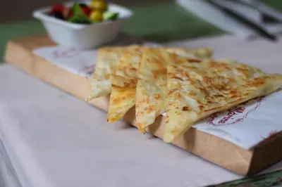 two slices of pizza on a cutting board with a salad at Frida Suites in Istanbul