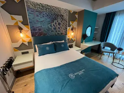 a bedroom with a large bed with a blue blanket at Royal Galata Hotel in Istanbul