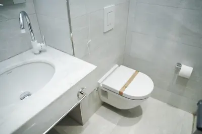 a white bathroom with a toilet and a sink at Royal Galata Hotel in Istanbul