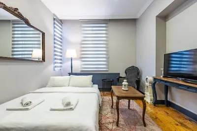 a bedroom with two beds and a flat screen tv at Ganbaru Tours - Flats in Galata in Istanbul