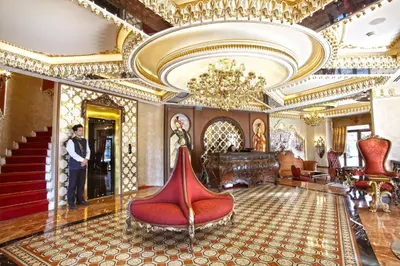 a man standing in a lobby with a room with gold at Daru Sultan Hotels Galata in Istanbul