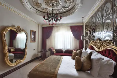 a bedroom with a large bed and a chandelier at Daru Sultan Hotels Galata in Istanbul
