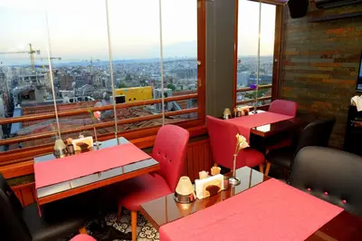 a restaurant with red tables and chairs and a large window at Pera Luna Residence in Istanbul