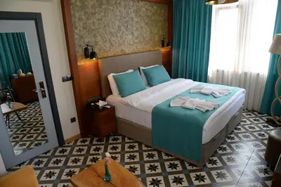 a bedroom with a bed with blue pillows and a mirror at Pera Luna Residence in Istanbul