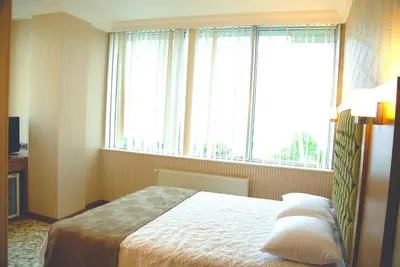 a bedroom with a bed and a large window at Lounge Hotel in Tuzla